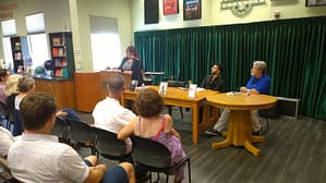 Jennifer reads from Demon's Prize while Dr. Navab, James Dorsey, and the audience listen with rapt attention.