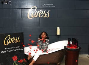 An attendee blows kissed in the Caress photo booth.